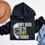 Introducing the ultimate hockey hoodie for all you puck-loving, goal-denying warriors out there! With our gender-neutral design, you'll look great whether you're body-checking your opponent or sipping hot cocoa in the stands. But the real star of the show is the goalie mask emblazoned with the words "My Goal Is To Deny Yours". It's like a personal challenge to every other player on the ice, and a declaration of your supreme goaltending skills (even if you're just a beginner). 