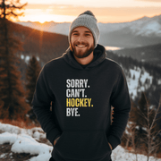Introducing the must-have hoodie for any hockey player, fan, or enthusiast: the Sorry. Can't. Hockey. Bye. hoodie! Perfect for those chilly days at the rink or just lounging at home, this gender-neutral hoodie is sure to make everyone laugh. Featuring a bold and hilarious design with a nod to Canadian hockey culture, this funny hockey hoodie is a great gift for any hockey player.