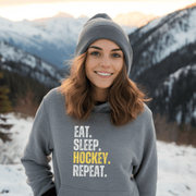 This hockey hoodie is not just any regular hoodie, it's the perfect blend of style, comfort and humor. With the catchy phrase "Eat. Sleep. Hockey. Repeat." printed on it, this hoodie is sure to grab attention and make heads turn. 