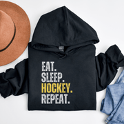 This hockey hoodie is not just any regular hoodie, it's the perfect blend of style, comfort and humor. With the catchy phrase "Eat. Sleep. Hockey. Repeat." printed on it, this hoodie is sure to grab attention and make heads turn. 