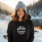This gender-neutral hoodie is perfect for anyone who loves hockey and is proud to show it. With a graphic featuring people playing pond hockey with a stunning mountain background, this hoodie is sure to turn heads and start conversations. 