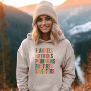 Introducing our new gender-neutral hoodie, perfect for embracing fall vibes. With its colorful fall palette and the saying "Flannels, Hayrides, Pumpkins, Bonfires, Sweaters" emblazoned on the front, this hoodie is the perfect addition to any fall wardrobe.