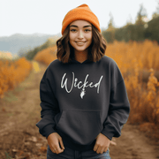 Our gender-neutral hoodie is the perfect addition to your spooky wardrobe, and it's guaranteed to make heads turn. With the wickedly cool design of a witch's broom and the word "Wicked" emblazoned across the front, this sweater will have you feeling like the baddest witch in town.