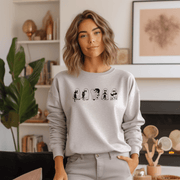  This gender-neutral sweatshirt is perfect for the upcoming Spooky Season, featuring adorable ghosts holding black cats. It's the perfect way to show off your love for Halloween, ghosts, and cats all at once.