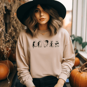  This gender-neutral sweatshirt is perfect for the upcoming Spooky Season, featuring adorable ghosts holding black cats. It's the perfect way to show off your love for Halloween, ghosts, and cats all at once.