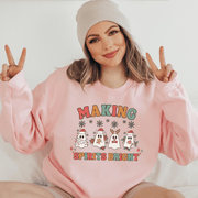 Introducing the festive sweatshirt that will make you the life of any holiday party! This gender-neutral sweatshirt features the cutest ghosts wearing Santa hats with the saying "Making Spirits Bright".