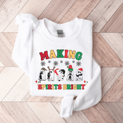 Get ready to spread some serious holiday cheer with our cute Christmas shirt featuring adorable ghosts wearing Santa hats and holding black cats with the saying "Making Spirits Bright".
