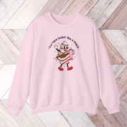 Our gender-neutral pullover features an adorable Christmas tree cake holding a sturdy Stanley water bottle, and flaunting a belt bag with a sassy message that reads "Out here lookin' like a snack".