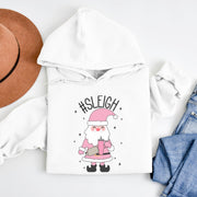 This gender neutral hoodie features a cute Santa holding a Stanley water bottle and sporting a trendy belt bag with the hashtag #SLEIGH. But wait, there's more! This hoodie is not just soft and comfortable, it's also magically warm - perfect for those cold winter nights. 