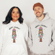 This cozy and stylish hoodie features a cute Christmas nutcracker holding a Stanley water bottle and sporting a trendy belt bag and is saying "What's Crackin'?", making this hoodie a conversation starter wherever you go.
