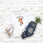 Our gender-neutral hoodie features a cute cartoon gingerbread woman who's ready to take on the world with her trusty belt bag and Stanley tumbler. 