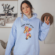Our gender-neutral hoodie features a cute cartoon gingerbread woman who's ready to take on the world with her trusty belt bag and Stanley tumbler. 