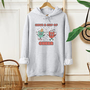 Slip into this cozy gender-neutral hoodie and feel the warmth of the cute cartoon cups of hot chocolate on your chest. It's like wearing a hug, but better because you won't overheat. 
