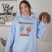 Slip into this cozy gender-neutral hoodie and feel the warmth of the cute cartoon cups of hot chocolate on your chest. It's like wearing a hug, but better because you won't overheat. 