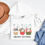  This cozy and comfortable gender-neutral hoodie is the ultimate gift for cat lovers and cupcake enthusiasts alike. Featuring adorable cartoon cats sitting in Christmas cupcakes, this hoodie is sure to bring a smile to anyone's face. 
