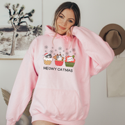  This cozy and comfortable gender-neutral hoodie is the ultimate gift for cat lovers and cupcake enthusiasts alike. Featuring adorable cartoon cats sitting in Christmas cupcakes, this hoodie is sure to bring a smile to anyone's face. 