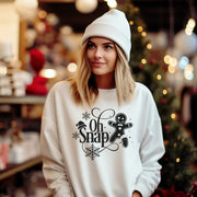 Our gender neutral sweatshirt features a charming gingerbread man with a broken leg, accompanied by the hilarious phrase "Oh Snap!". 