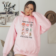 Our "These Are Some Of My Favorite Things" hoodie is the ultimate choice for anyone who loves to keep it cozy and festive during the holiday season. 