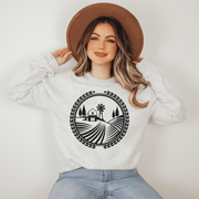 This gender-neutral sweatshirt features a unique graphic of a farmers field, showcasing the beauty of the prairie landscape and the importance of agriculture in Manitoba. 