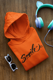 Introducing the perfect hoodie to brighten up even the gloomiest of days - the gender-neutral "Smile" hoodie! With a bold and playful "Smile" written across the front, and a cheeky smiley face sticking its tongue out, this hoodie is sure to put a grin on anyone's face. 